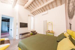 锡耶纳丰特盖亚之旅住宿加早餐旅馆的一间卧室设有一张绿色的床和一台电视。