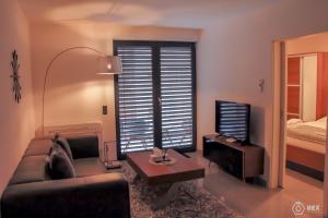杜塞尔多夫蓝石公寓式酒店的带沙发、桌子和电视的客厅