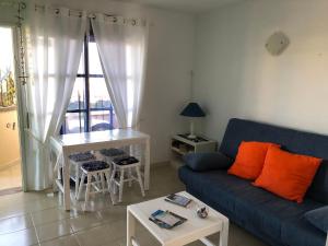 科斯塔德安提瓜Fuerteventura Resort Bouganville的客厅配有蓝色的沙发和桌子