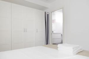 吉塔里亚BALENTZIAGA Getaria的带淋浴和床的白色卧室