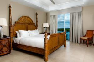 格雷斯湾Blue Haven Resort- All Inclusive的一间卧室设有一张床和一个大窗户