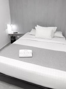 波哥大KLEINN HOTEL BOGOTÁ的一张黑白的床铺照片,上面有一条毛巾
