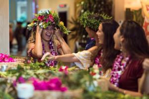 檀香山卡皮欧拉尼皇后酒店的一群坐在桌子上的女人,头上花
