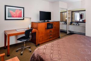 霍布斯贝斯特韦斯特行政酒店的酒店客房配有书桌和电视。