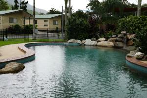 凯恩斯Cairns Crystal Cascades Holiday Park的一座游泳池,位于一个水中岩石的庭院内