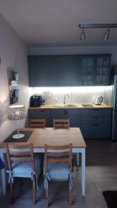 尤斯托尼莫斯基Apartament 13 Ustronie Morskie的厨房配有木桌、椅子和水槽