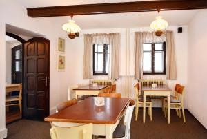 伊莱姆尼采Restaurace a penzion Jilm的用餐室设有桌椅和窗户。