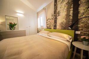 萨尔扎纳Gardenhouse Sarzana的一间卧室配有一张带绿色床头板的床和一张桌子