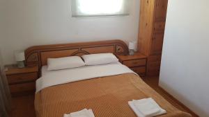 LiádhaG-George Apartments by the Sea and Airport的一间卧室配有一张带两条白色毛巾的床