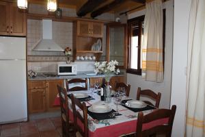 卡皮雷拉Apartamentos Rurales Rosendo: La Albahaca的一间带桌椅的厨房和一间带桌子的厨房