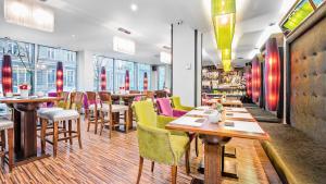波兹南丹普雷斯提齐酒店的餐厅设有木桌和五颜六色的椅子
