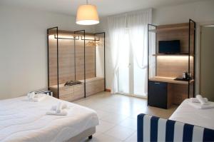 里乔内Hotel Majorca sul Mare in centro a Riccione的酒店客房设有两张床和电视。