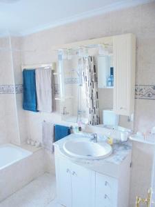 罗哈莱斯Pancho Apartment Doña Pepa - C. Quesada的白色的浴室设有水槽、浴缸和镜子