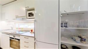 塞伊奈约基Pirjola的白色的厨房配有冰箱和水槽