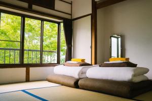 箱根箱根帐篷温泉旅馆的窗户前设有两张床的房间