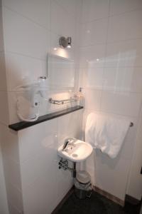鹿特丹比弗维纽酒店的白色的浴室设有水槽和卫生间。