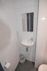 鹿特丹比弗维纽酒店的白色的浴室设有水槽和镜子