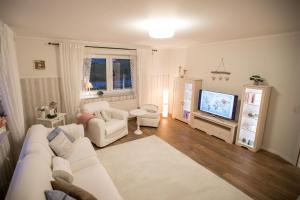斯维斯塔尔Landhaus的客厅配有白色沙发和电视