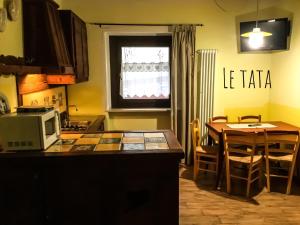 奥斯塔Chèvres à Cheval - Apartment的厨房配有桌子、微波炉和桌椅。