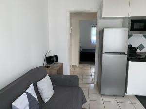 鲁瓦扬Appartement des Tilleuls RDC的带沙发和冰箱的客厅