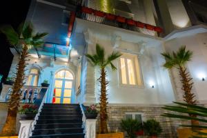 地拉那ART Hotel Tirana的大堂,棕榈树和楼梯位于大楼内