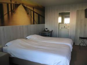 鲁瑟拉勒璨多尔酒店的卧室设有一张白色大床和楼梯。