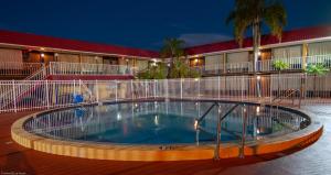 克利尔沃特Express Inn & Suites - 5 Miles from St Petersburg Clearwater Airport的夜间在酒店前的游泳池