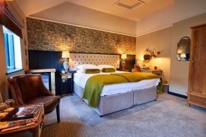 赛伦塞斯特赛伦塞斯特羊毛宾馆 的配有一张床和一把椅子的酒店客房