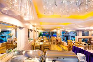 河内河内蓝天酒店的餐厅设有桌椅和吊灯。