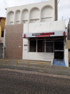 特雷西纳Pousada Executiva的前面有两长椅的建筑