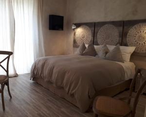 阿尔贝罗贝洛席尔瓦酒店的一间卧室设有一张大床和一台墙上的电视。
