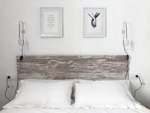 科尔多瓦Apartamento Homies Córdoba的一张带两个白色枕头的床和墙上的两张照片