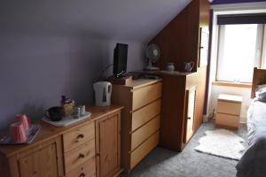 克里夫Bridgehill Cottage Bed & Breakfast的一间卧室配有一张床和一个带电视的梳妆台