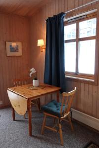 安德内斯Fredheimbrygga的客房设有木桌、椅子和窗户。