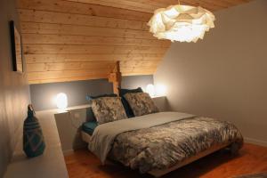 BégardGites du Hérisson的一间卧室配有一张床和一个吊灯
