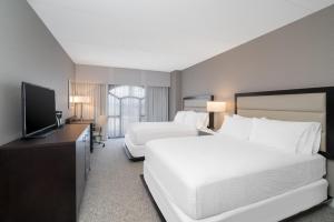 Gurneyville威尔明顿假日酒店的酒店客房设有两张床和一台平面电视。
