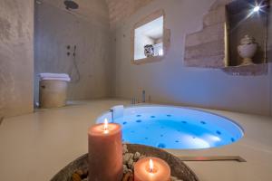 栋纳富加塔Terre di Cavalusi Relais的浴室设有浴缸,内配两根蜡烛