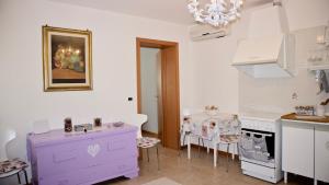 威尼斯Appartamento Ca' Di Nive的厨房配有紫色橱柜和桌椅