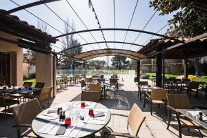 阿维尼翁Hôtel Paradou Avignon Sud的餐厅设有桌椅和玻璃天花板