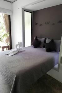 诺萨拉绿色保护区酒店的一间卧室配有一张带白色丝带的大床