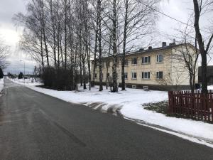 MikitamÃ¤eSoelaane 12 Apartments的一条空荡荡荡的街道,有楼房,有树和雪