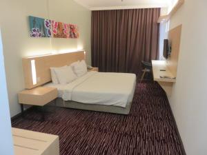 加影RHR Hotel Kajang的酒店客房,配有床和电视