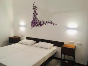 科伦坡Visakha 6的一间卧室设有两张床,墙上挂有一幅花画