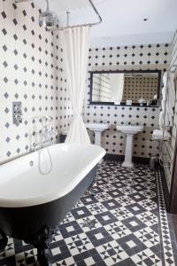 伦敦Boundary Shoreditch的浴室设有白色浴缸和黑白瓷砖。