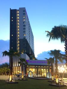 洛坤府Grand Fortune Hotel Nakhon Si Thammarat的一座棕榈树环绕的大建筑