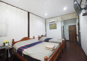 曼谷奥博阿伦之家住宿加早餐旅馆的一间卧室配有两张床和一张桌子