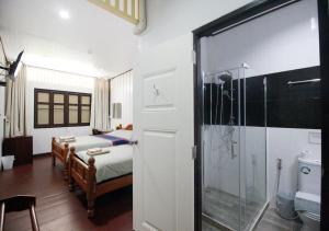 曼谷奥博阿伦之家住宿加早餐旅馆的一间卧室配有一张床和淋浴,还有一间浴室