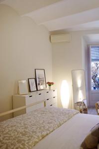 帕拉弗鲁赫尔Apartament en Plaça Nova , Palafrugell的一间卧室配有一张床、一个梳妆台和一扇窗户。