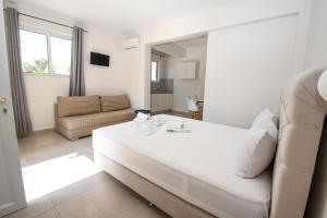 卡拉马孔Kalamaki Zakynthos Apartments的白色的客厅配有沙发和桌子