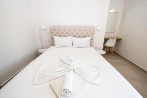卡拉马孔Kalamaki Zakynthos Apartments的卧室配有白色的床,上面有弓